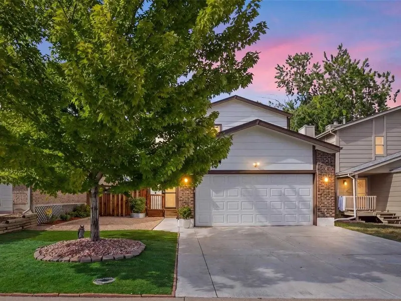 Two-story home with a front tree and two-car garage at 5671 West 71st Avenue in Arvada, Colorado.